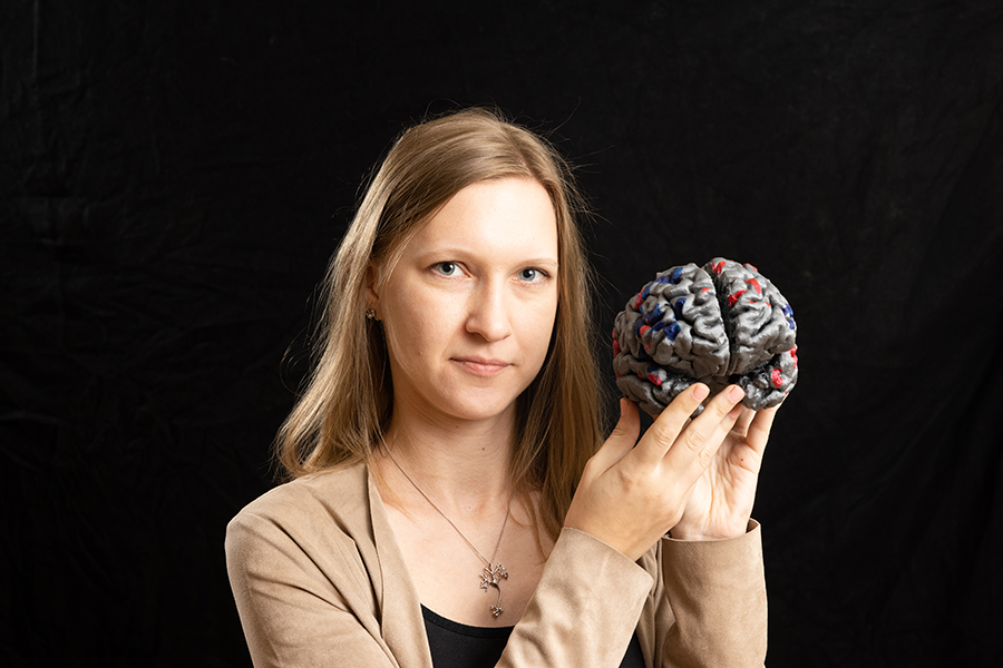 Woman holds brain and looks at camera